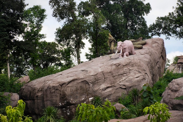 Elephant and Naga big snake on cliff stone in Wat Tham Klong phen forest temple for Thai people and foreign travelers travel visit respect praying at Phu Phan mountain in Nong Bua Lamphu Thailand