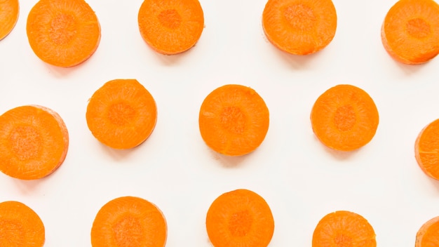 Elevated view of carrot slices on white backdrop