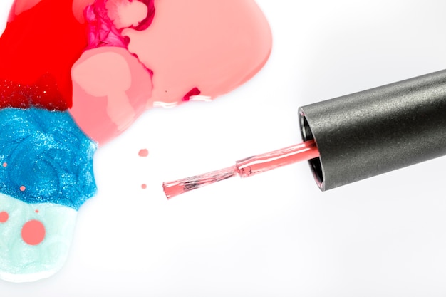 elevated view of colorful nail polish and brush on white background