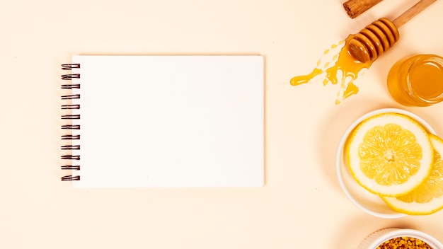 Фото Повышенный вид пустого блокнота с ломтиком лимона и медом
