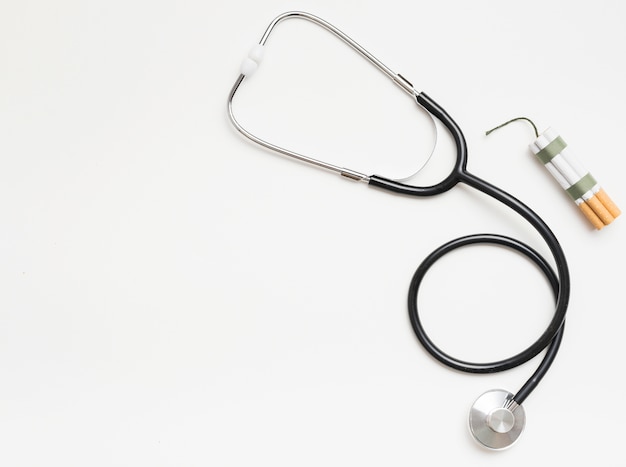 Photo elevated view of stethoscope and cigarette on white backdrop