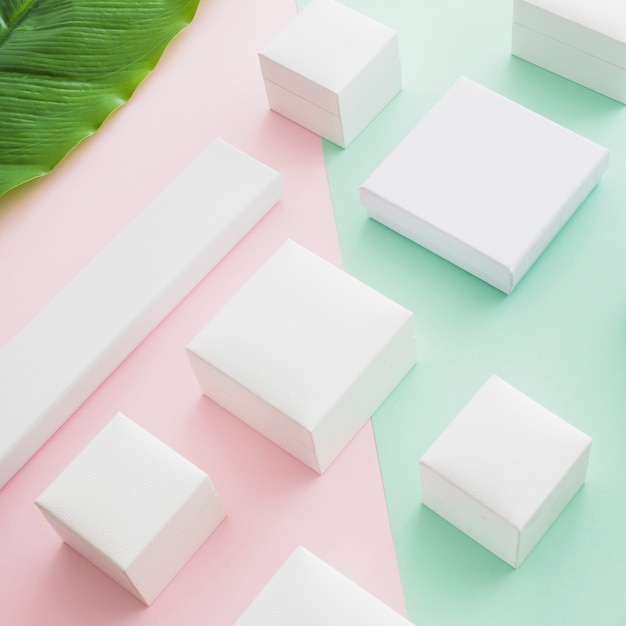 Elevated view of white boxes on colored paper backdrop