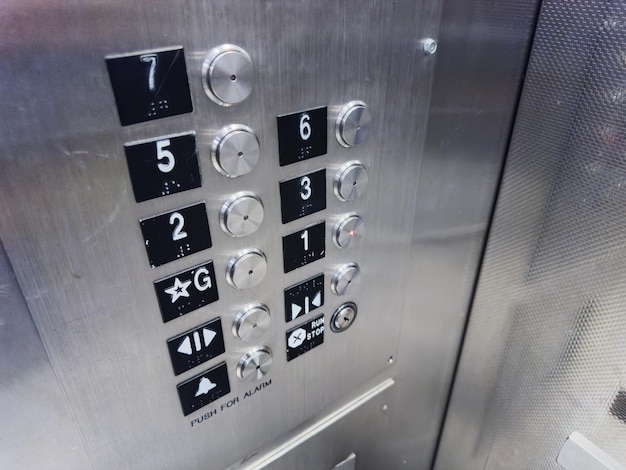 elevator sign and button panel casting a warm glow in a dimly lit corridor symbolizing accessibili