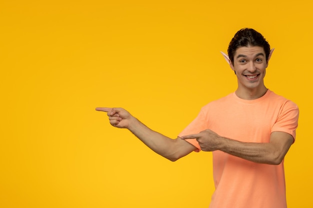 Elfenkerel gelukkige knappe mooie kerel in oranje t-shirt die elforen draagt en lacht