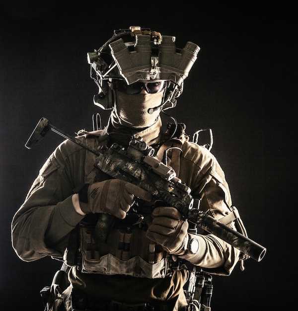 Elite commando fighter private military company mercenary special operations serviceman security or secret service shooter equipped modern weapons and ammunition studio shoot on black background