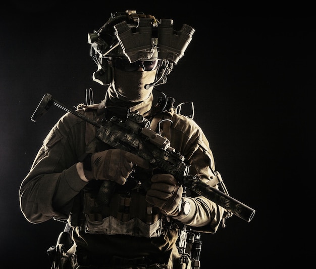 Elite commando fighter private military company mercenary special operations serviceman security or secret service shooter equipped modern weapons and ammunition studio shoot on black background