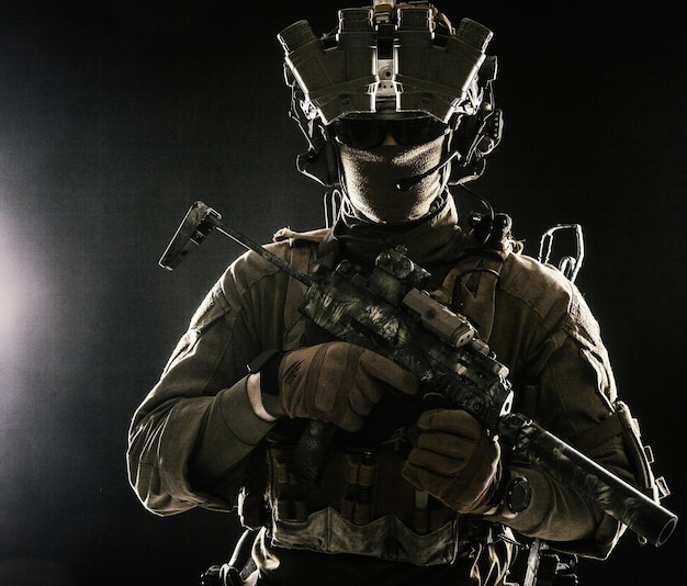 Elite commando fighter private military company mercenary special operations serviceman security or secret service shooter equipped modern weapons and ammunition studio shoot on black background