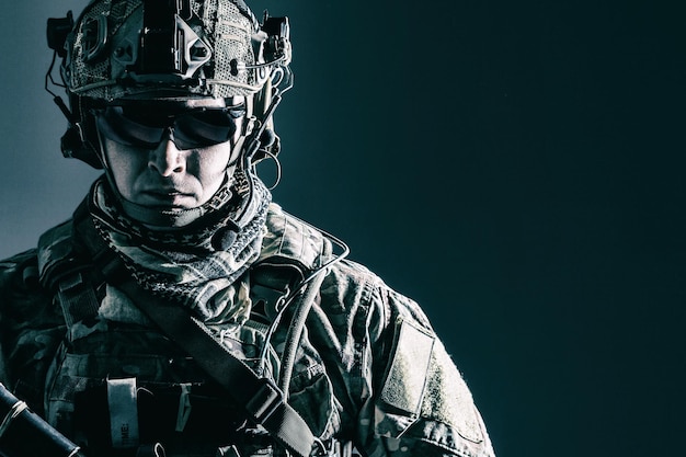 Elite lid van us army rangers in gevechtshelm en donkere bril. studio opname, donkere zwarte achtergrond, camera kijken, donker contrast