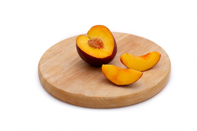 Elk of nectarine met gesneden stukken op houten plaat