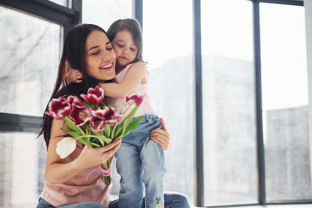 Elkaar omhelzen Dochter feliciteert moeder met vakantie en geeft boeket bloemen