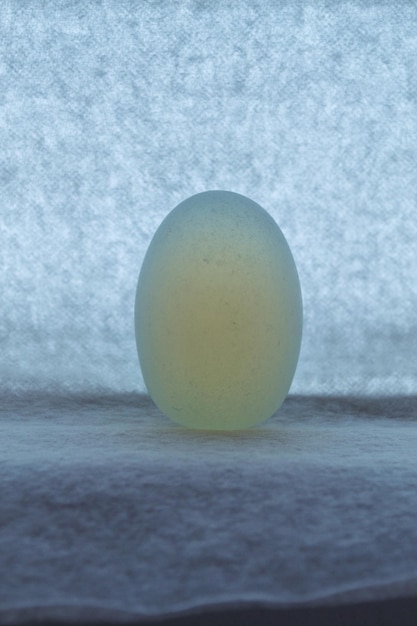 Фото Полудрагоценный камень в форме эллипса на бумаге