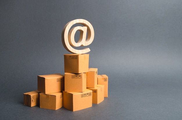 The email symbol commercial AT is on cardboard boxes stack. E-commerce