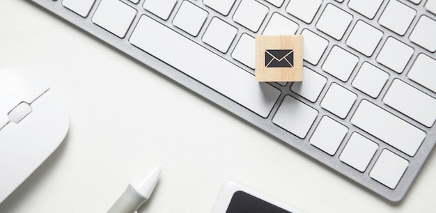 Email symbol on the wooden cube. Business desk