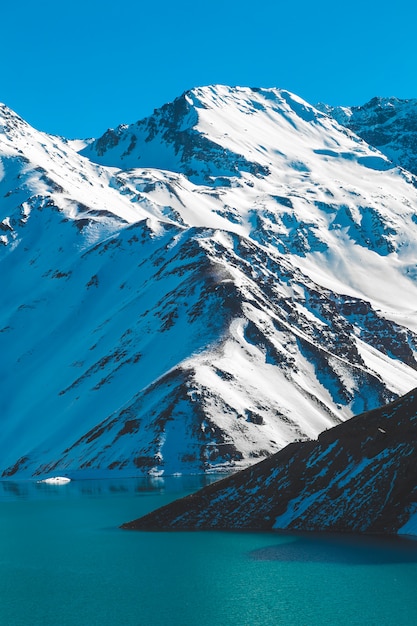 Foto embalse el yeso // besneeuwde bergketen met een lagune