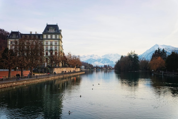 Embankment and mountains in the Old Town of Thun. Thun is a city in Swiss canton of Bern, Switzerland. It is located where Aare river flows out of Lake Thun.
