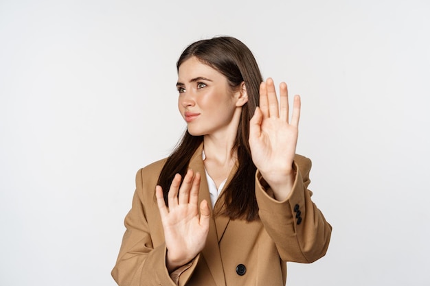 Embarrassed woman turn away from something disgusting, refusing, rejecting, standing displeased against white background