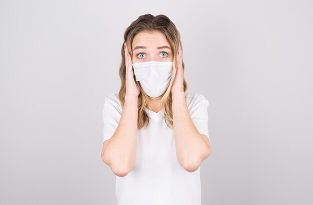 Embarrassed Young caucasian woman wearing medical mask