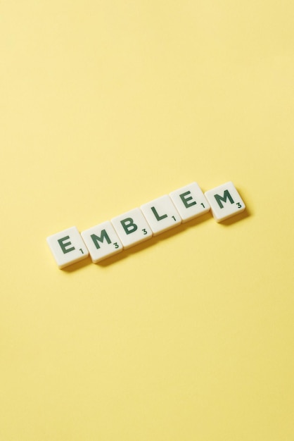 Emblem formed of scrabble tiles on yellow background