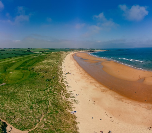 Embleton Bay and Burn sandy beach with the ruins of Dunstanburgh Castle