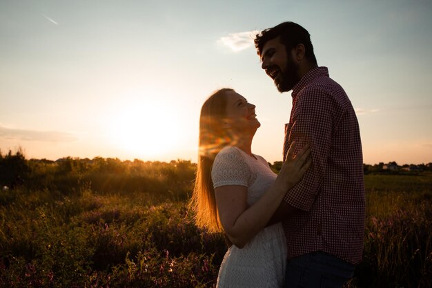 Embracing couple in rays of setting sun