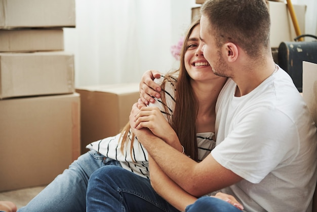 Embracing each other. Cheerful young couple in their new apartment. Conception of moving.