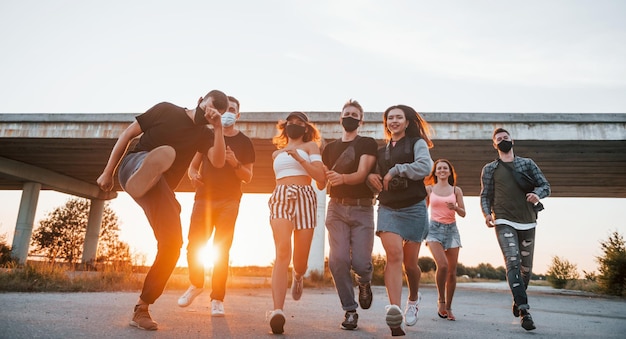 Embracing each other Group of young cheerful friends having fun together Party outdoors