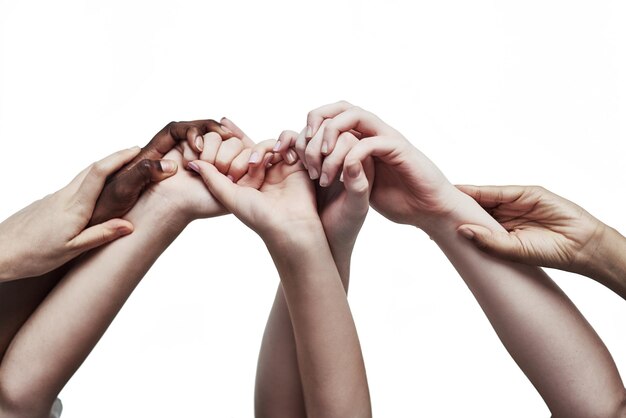 Photo embracing unity through diversity shot of a group of hands holding on to each other against a white background             person