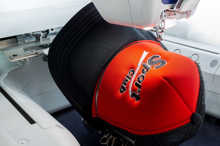 Embroidered sport cap and embroidery machine close up picture
