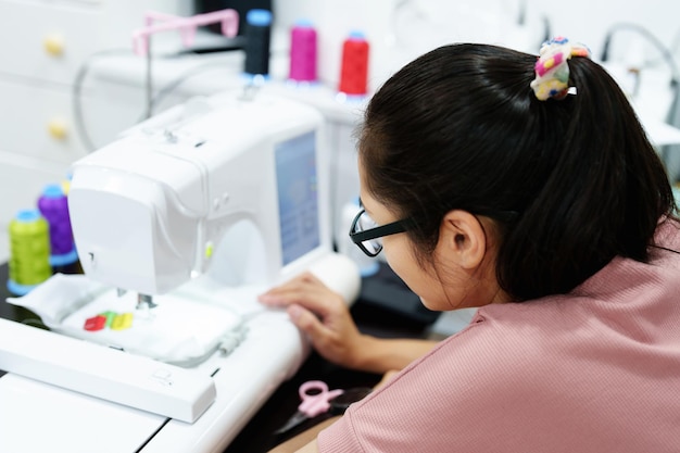 刺繡手工芸品趣味SMEビジネスファミリービジネスアジアの女性デザイナーの肖像画は、顧客の注文に応じて自動刺繡機を使用してパターンをデザインしています