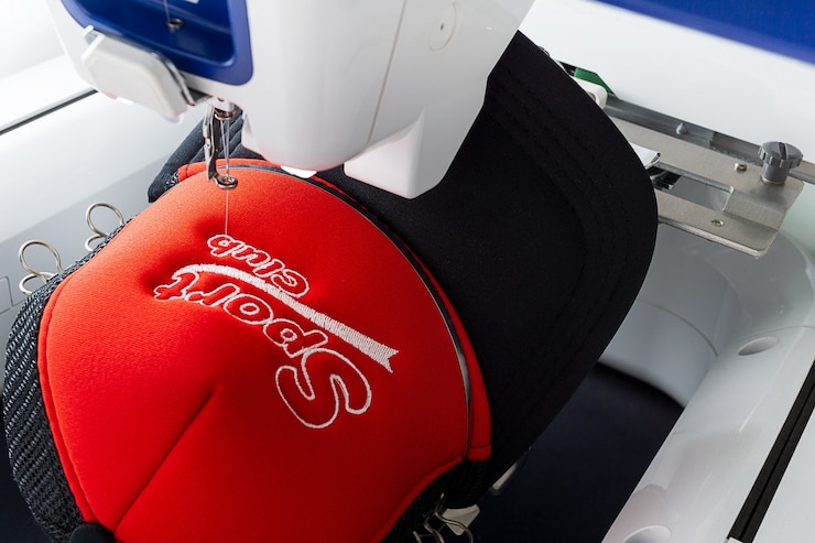 Embroidery machine and embroidered sport cap close up image