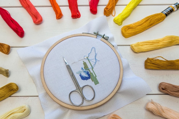 Embroidery prosees on the table with coloful threads.