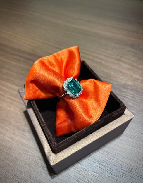 Emerald and diamond ring on orang satin lace