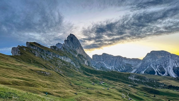 Photo emerald valleys cradle the dolomites' sheer cliffs basking in italy's pristine daylight