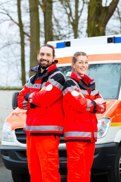 Foto medico di emergenza e infermiere in piedi davanti all'auto dell'ambulanza