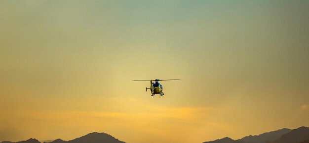 Emergency helicopter firefighters with the last hours of the sunset sun performing the maneuvers