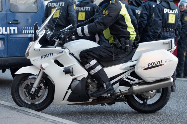 Photo emergency road and motorcycle police officer working for protection and peace in an urban town in denmark security traffic and legal professional or policeman on a motorbike ready for service