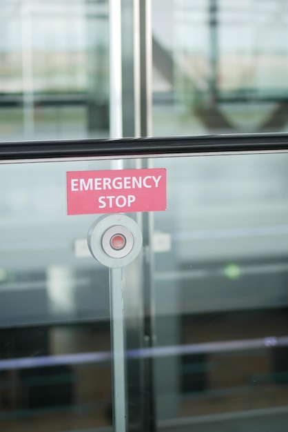 an emergency stop button is placed on a glass wall in a public space for safety measures
