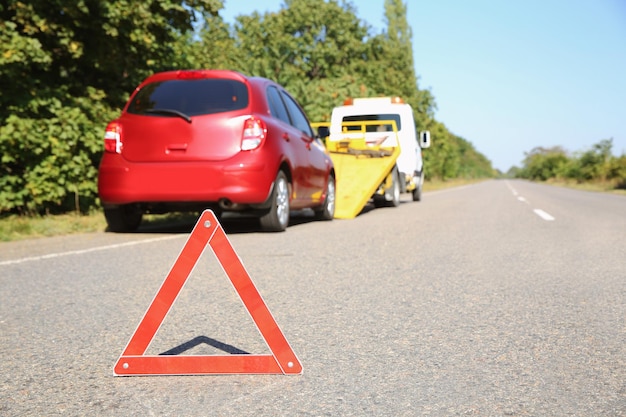 Emergency stop sign with broken car and tow truck on background Space for text