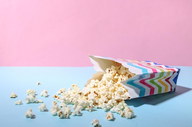 Emmer bestrooide popcorn op blauw roze pastelachtergrond