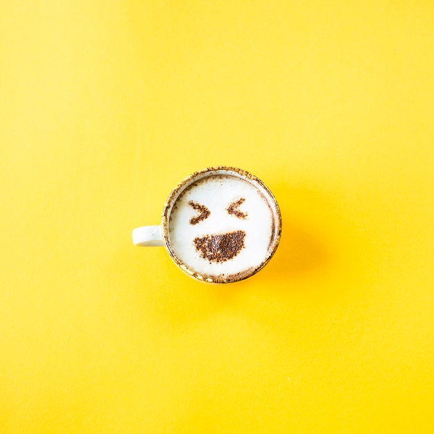 Foto emoji's lach wordt getrokken door een kopje cappuccino-koffie