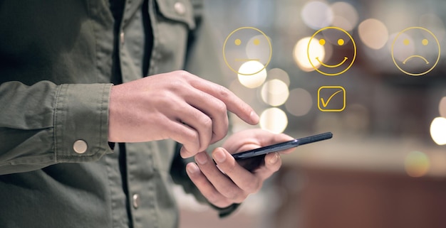 Emoticon icons and check mark Quality control Man tapping on phone screen