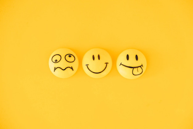 Photo emoticon icons funny faces on yellow background. minimal concept. top view. copy, empty space for text