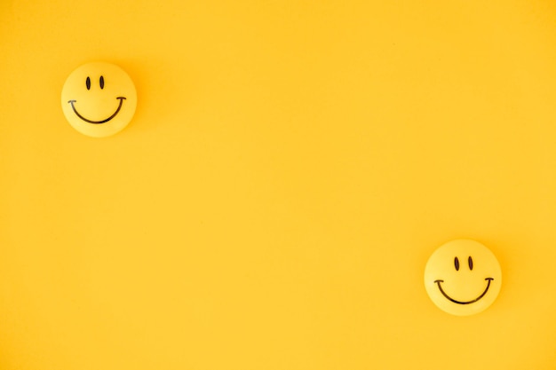 Emoticon icone facce buffe su sfondo giallo. concetto minimo. vista dall'alto. copia, spazio vuoto per il testo