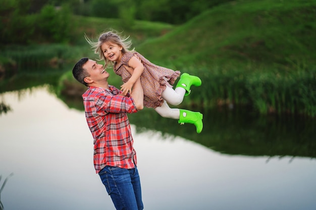 Emoties van geluk. Vader gooit zijn dochtertje in zijn armen. Papa's dag