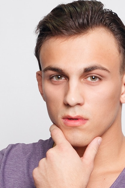 Emotion, advertisement and people concept - Handsome young man on grey surface looking at camera