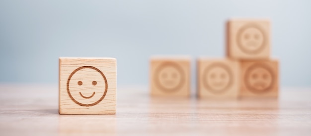 木製のブロックの感情の顔のシンボル。サービスの評価、ランキング、カスタマーレビュー、満足度、評価、フィードバックの概念