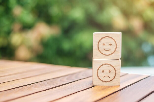 Photo emotion face symbol on wooden blocks. service rating, ranking, customer review, satisfaction, evaluation and feedback concept