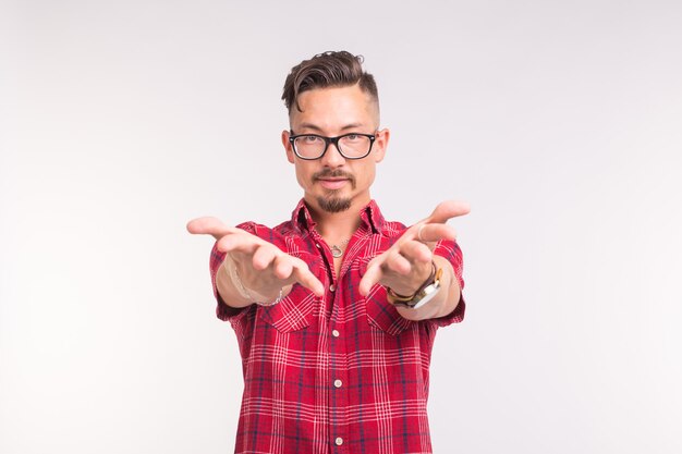 Emotion, help, people and gesture concept - young handsome man stretches hands forward on white