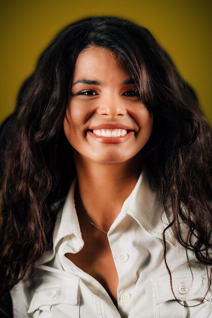 Emotion Pride Face of a beautiful happy young woman smiling and feeling pride studio portrait yellow background