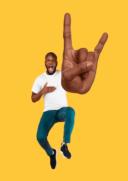 Emotional african american guy showing rock on gesture